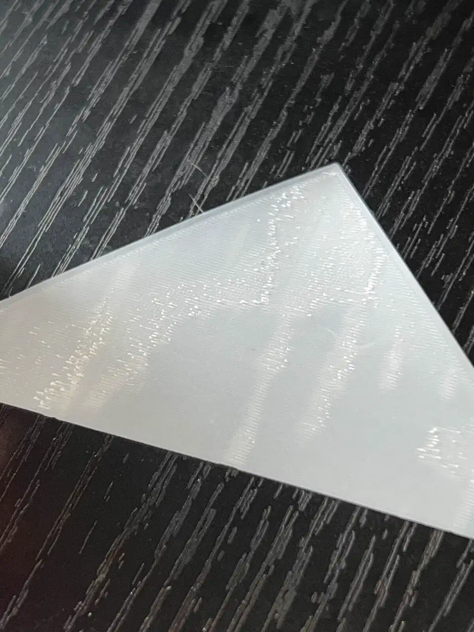 Underside of a white lithophane print from a new SuperTack showing a rough, scratchy first layer with visible ridges