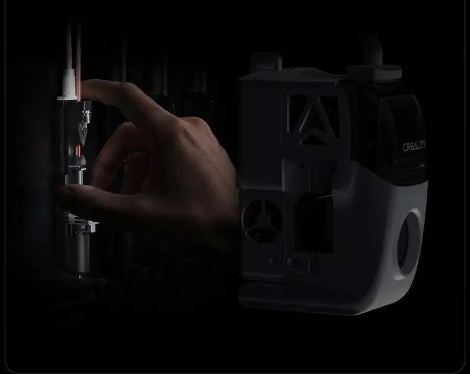 A hand lifting the Creality KliTek toolhead module off its mount inside the printer chamber