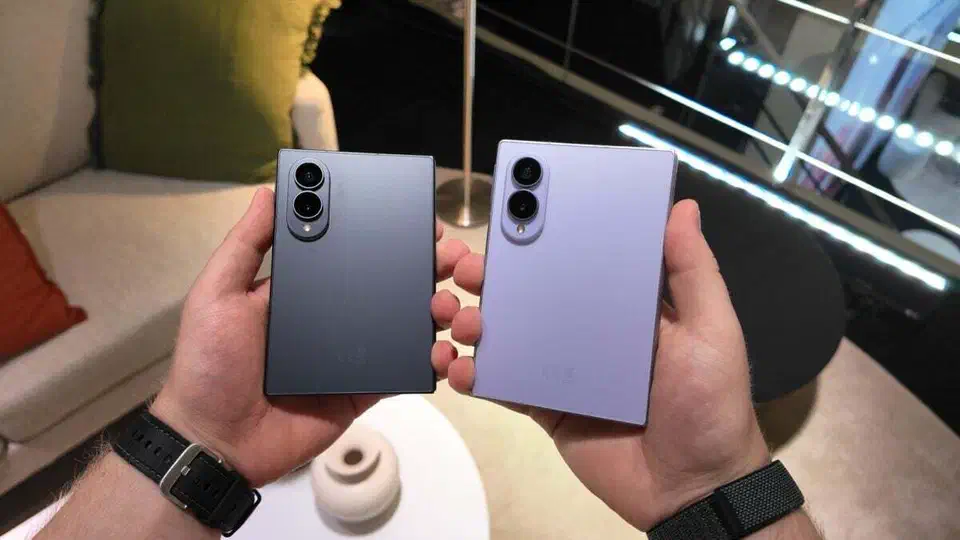 Two folded Galaxy Z Fold 8 handsets held side by side, one in graphite and one in lavender, showing the short wide closed shape and the two-lens camera bump