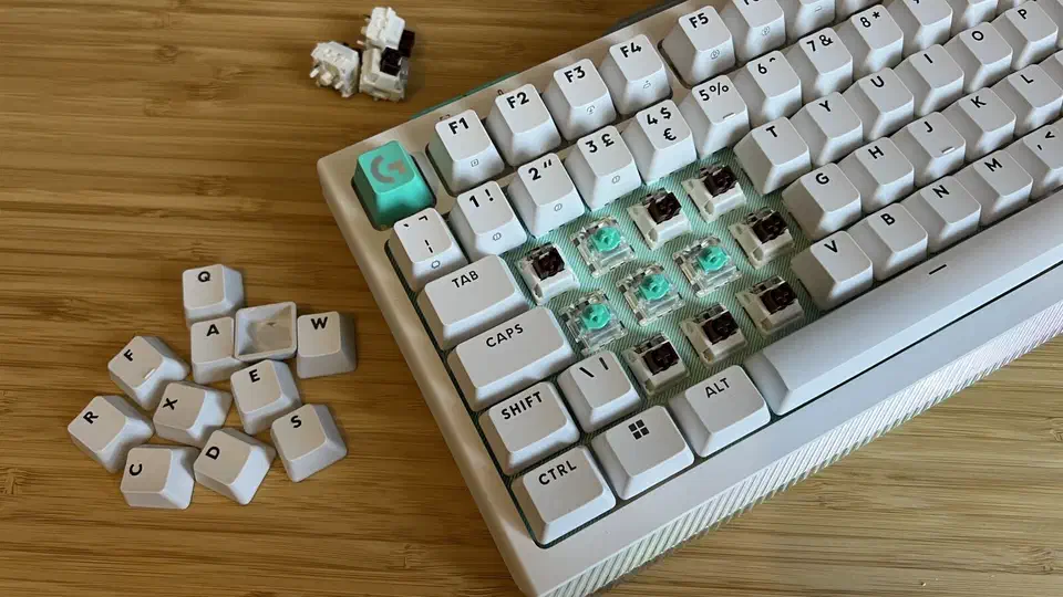 G512 X with keycaps removed around WASD, showing brown mechanical switches and teal analog switches sitting in the same sockets
