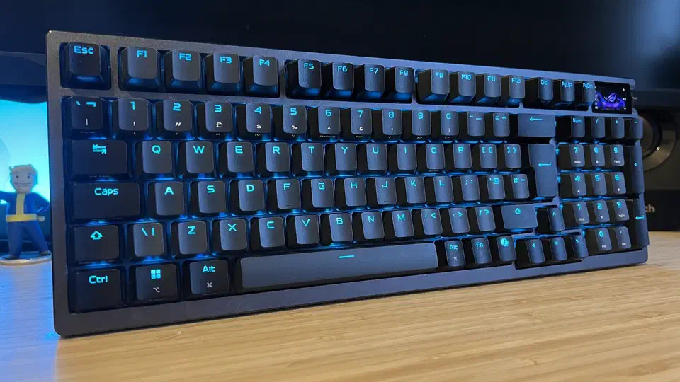 Asus ROG Azoth 96 HE photographed at desk level, showing the 96 percent layout with a number pad and a visible gap between the arrow keys and the number block