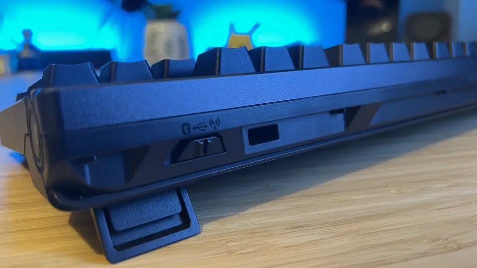 Close-up of the left edge of the Asus ROG Azoth 96 HE showing the three-position connection slider marked with Bluetooth, USB and 2.4GHz wireless icons