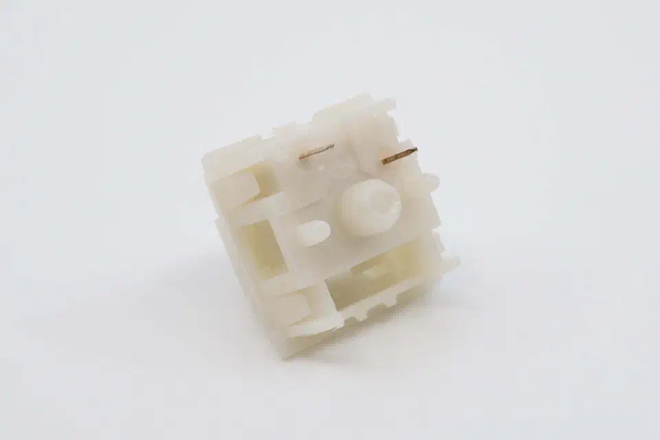 Underside of a Boba U4 switch showing the central pole, two metal contact pins, and plastic mounting legs