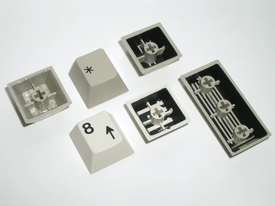 Six Cherry double-shot keycaps, two face up with black legends and four flipped over to show the dark legend plastic inside