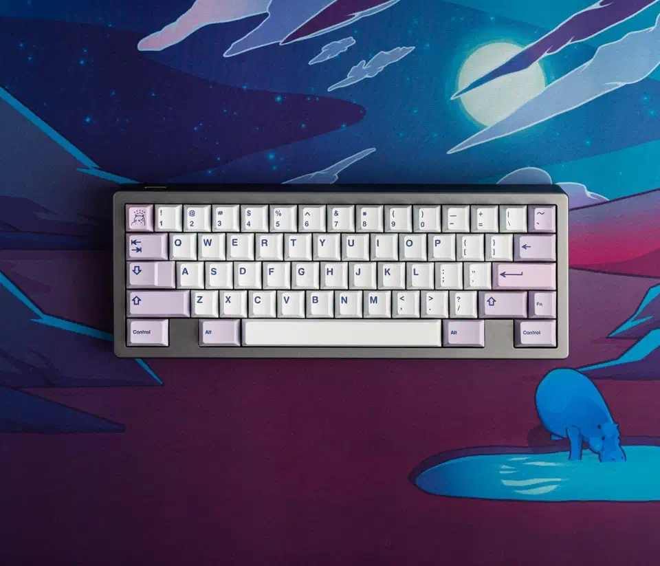 Keyboard fitted with lilac and white PolyCaps Hippo PBT keycaps with dark legends, resting on an illustrated desk mat