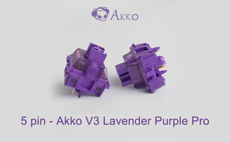 Two purple Akko V3 Lavender Pro 5-pin switches showing two gold metal pins plus three plastic legs on the underside