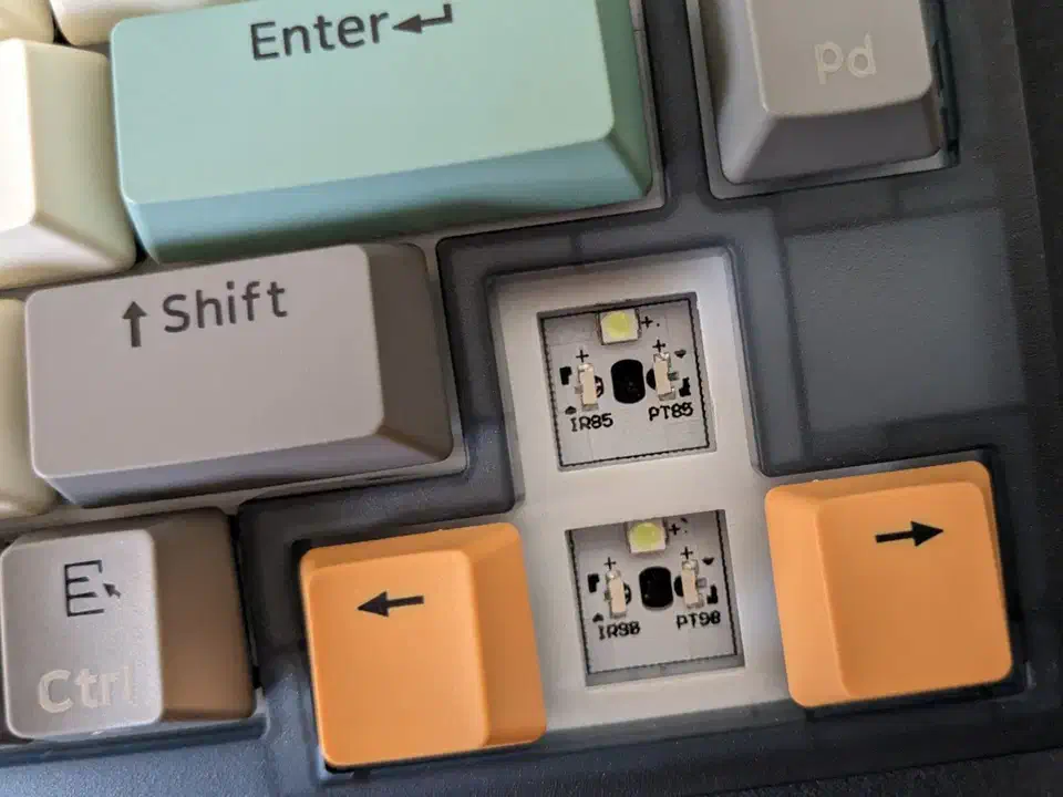 Optical keyboard switch sockets on a PCB with the IR85 infrared emitter and PT85 phototransistor visible beside empty switch holes