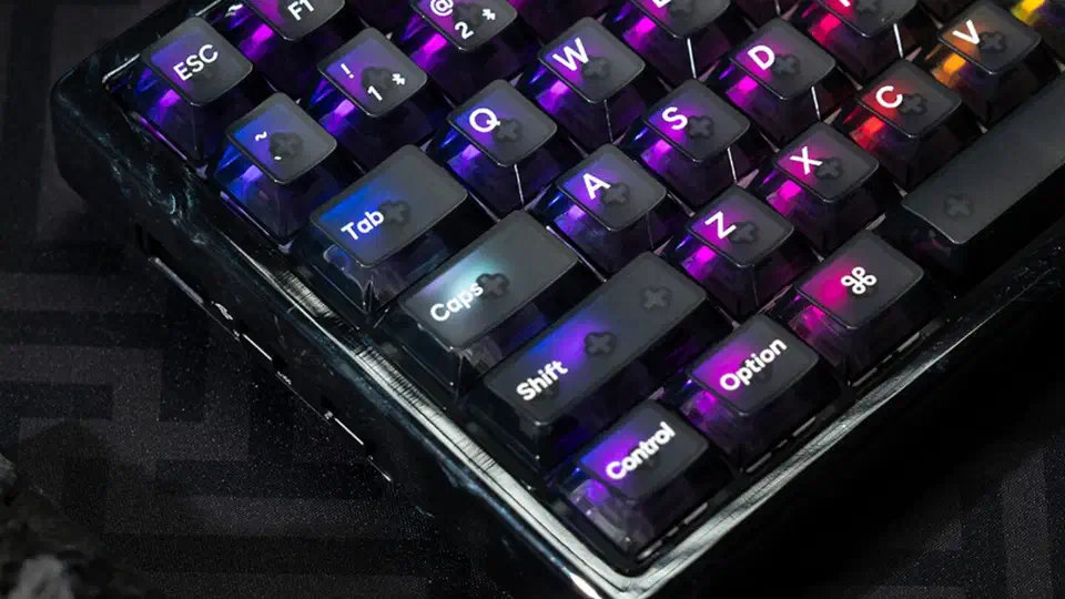 Corner of the resin edition K2 HE with smoky translucent keycaps lit purple, blue, and red by north-facing per-key RGB
