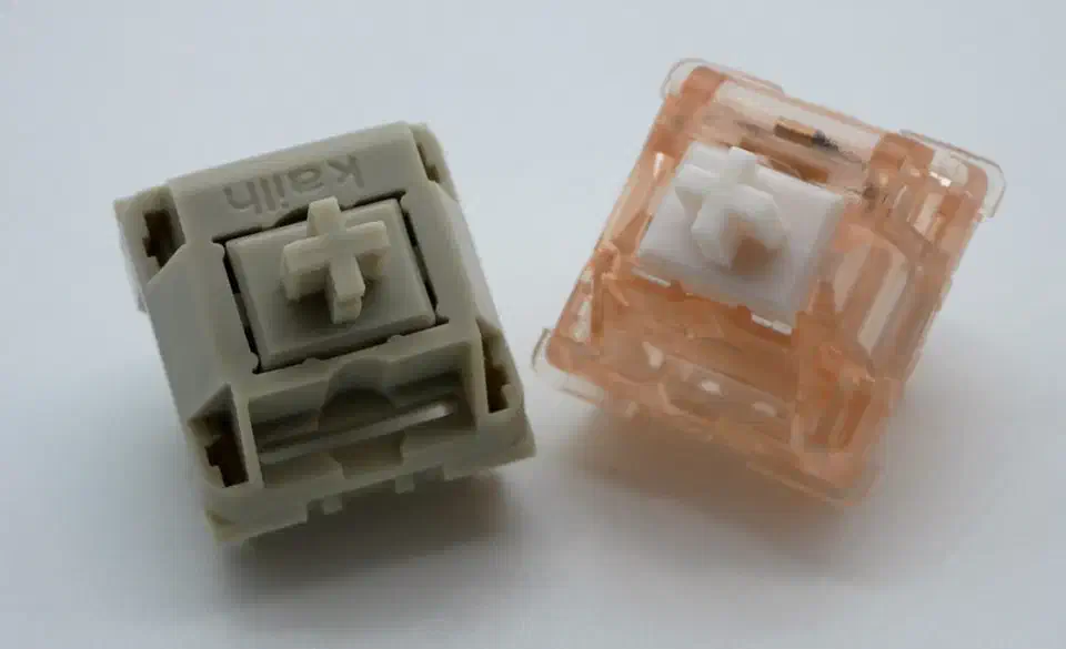 Keyboard switches built around conical springs, the Novelkeys Arc Cream and Quartz, with the flared coil shape visible