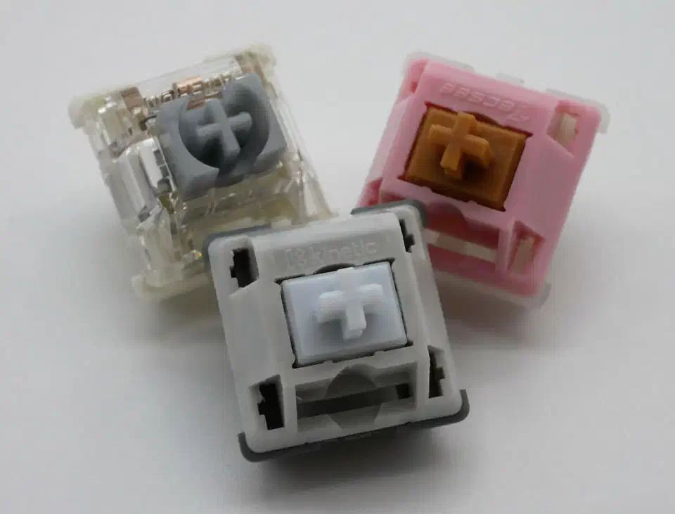 Three keyboard switches that use multi-stage springs: the Gateron Pro 2.0 Silver, Neapolitan Ice Cream and Husky Linear, shown with their housings open