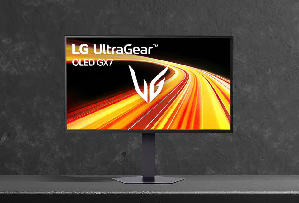 LG UltraGear evo OLED monitor on a dark surface, thin bezel and pedestal stand, screen showing orange and red light streaks
