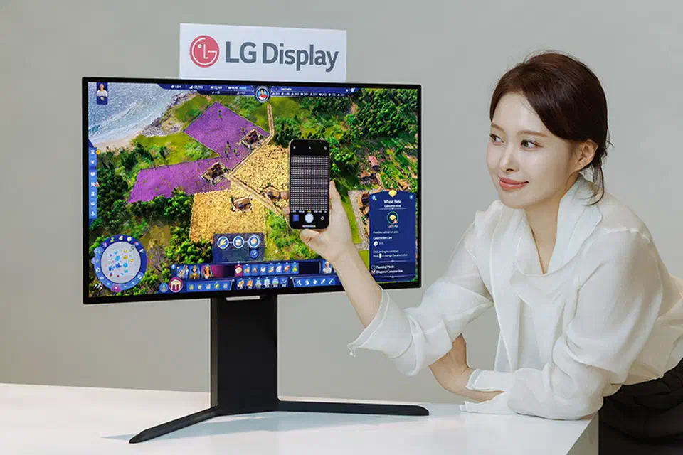 LG Display&rsquo;s 27-inch 4K RGB-stripe OLED panel shown in a monitor, with a phone held up to magnify the sub-pixels on screen