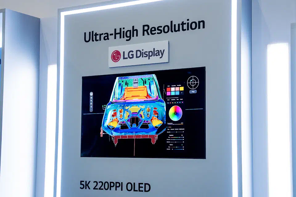 LG Display&rsquo;s 27-inch 5K Tandem WOLED panel on a trade-show wall labelled &ldquo;5K 220PPI OLED&rdquo;, showing a colorful automotive CAD render