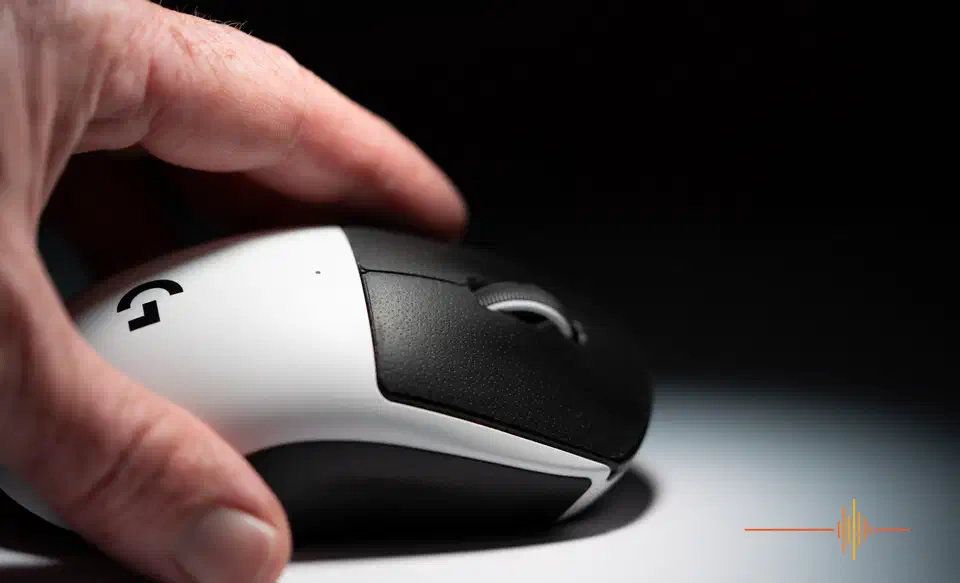 Fingertip resting on the left button of the white and black Logitech G Pro X2 Superstrike, side view under studio lighting