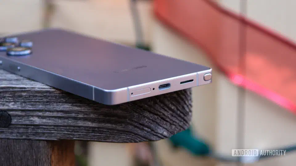 Galaxy Ultra resting on a wooden rail, photographed edge on so the USB-C port and the full depth of the frame are visible