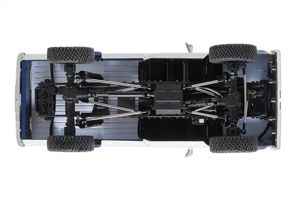 Underside view of the FMS FCX18 II F-100 showing the straight front and rear axles, diff housings, drive shafts, links and central skid plate