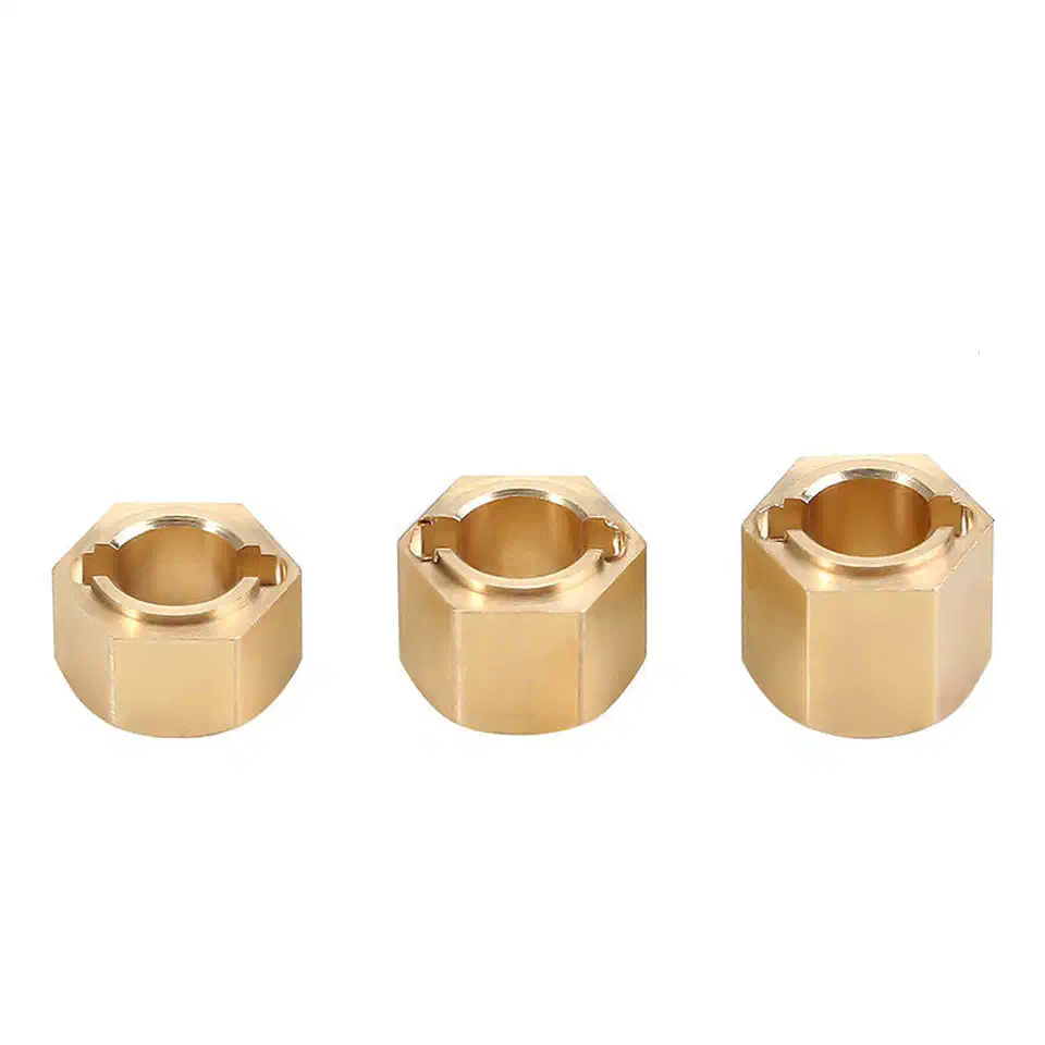 Three brass hex wheel hub extenders of increasing depth standing upright in a row