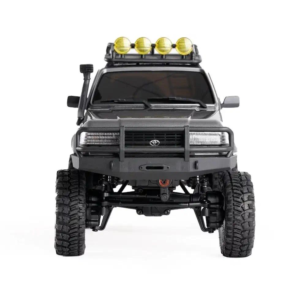 Head-on view of the gray FMS FCX18 LC80 showing the front portal axle housing sitting above the wheel centres and the gap under the differential