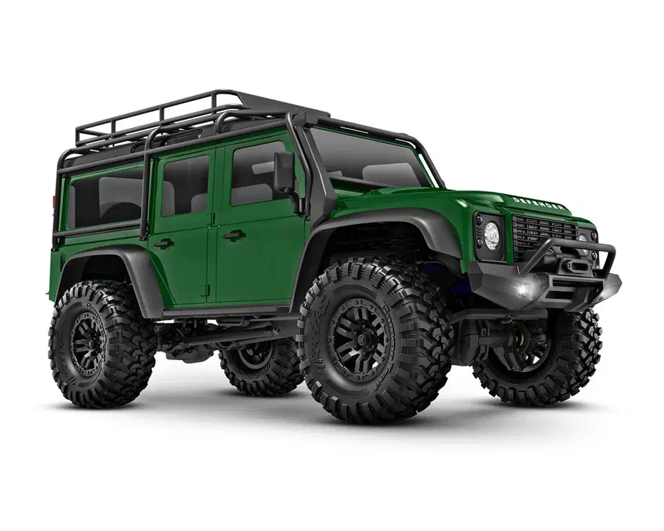 Traxxas TRX-4M Defender in green, front three-quarter view showing the chunky vented stock tires and low-slung straight front axle