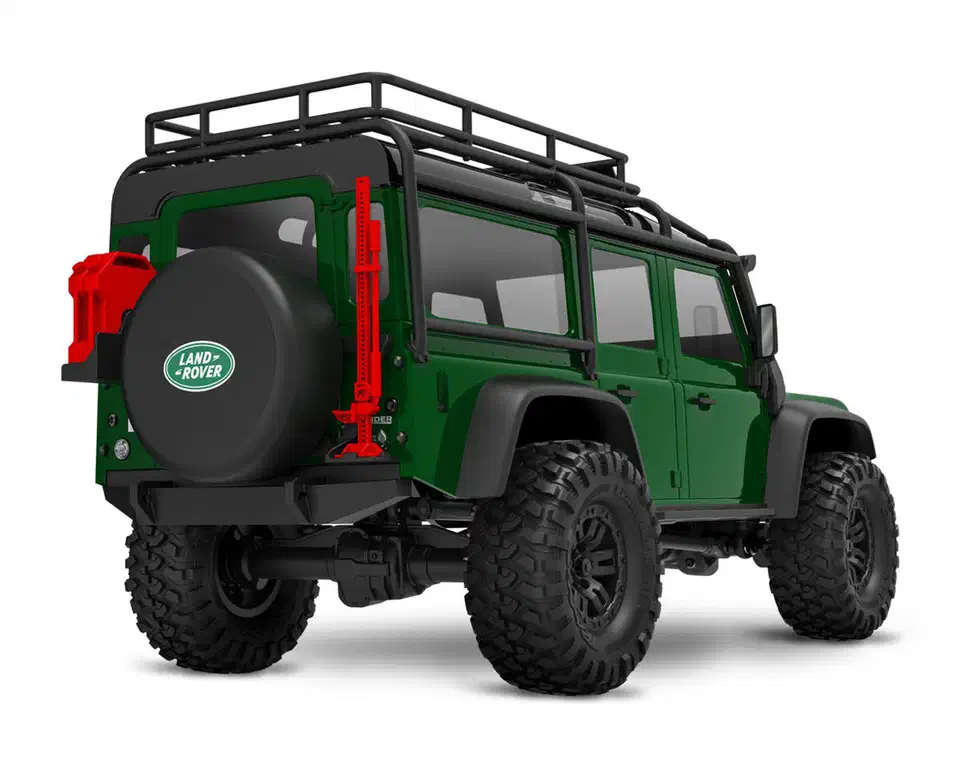Traxxas TRX-4M Land Rover Defender in green, rear three-quarter view showing the spare wheel cover, red jack, fuel cans and rear straight axle