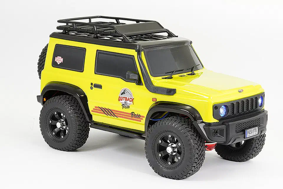 FTX Outback 3 1/10 crawler with a yellow Suzuki Jimny body, roof rack, and off-road tires