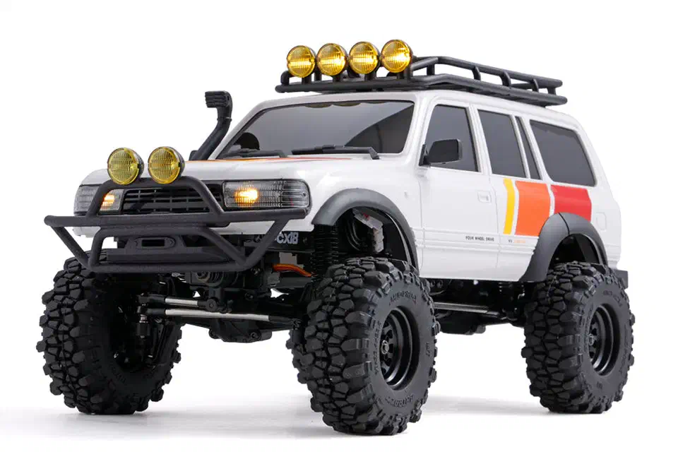 White FMS FCX18 LC80 Tri-Color V2 crawler with black tube bumper, roof rack, six yellow spot lamps and knobbly tires